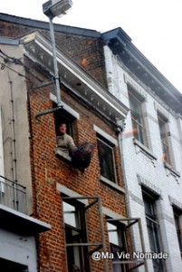 Un homme à sa fenêtre s'amuse à attraper des oranges